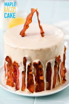 a white cake with bacon on it sitting on a plate