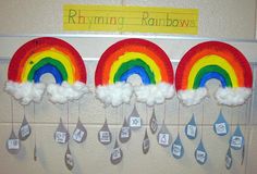 rainbows and clouds are hanging on the wall in front of a bulletin board that says rhyming rainbows