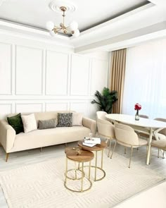 a living room filled with furniture next to a white dining room table and two chairs