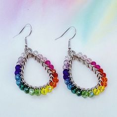 These lovely earrings are handmade using colorful crystal glass beads. The beads are carefully and individually wrapped around silver teardrop pendants with silver plated, tarnish-resistant wire and hang from hypoallergenic 925 sterling silver earring hooks. The earrings measure approximately 2" long from the top of the earring hook to the bottom teardrop pendant. (Please see the pictures that include a measuring tape and/or quarter for size reference.)  They are perfect to give as a gift or to treat yourself to something special.  Colors may appear slightly different in images when displayed on your screen. Cotton Filled Box Included. Handmade in the USA. ------  Find more Beautiful Pieces at AshbeesAccessories 🛍 Shop: https://www.etsy.com/shop/AshbeesAccessories Necklaces: https://www.e Teardrop Crystal Earrings With Faceted Beads, Beaded Teardrop Crystal Earrings, Handmade Teardrop Czech Glass Crystal Earrings, Silver Teardrop Beaded Earrings With Colorful Beads, Handmade Multicolor Teardrop Crystal Earrings, Nickel-free Multicolor Teardrop Crystal Earrings, Silver Teardrop Earrings With Colorful Beads, Wire Wrapped Czech Glass Teardrop Beaded Earrings, Handmade Teardrop Crystal Earrings