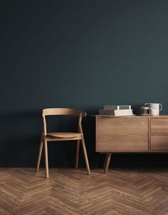 two chairs sitting next to each other on top of a wooden floor in front of a blue wall