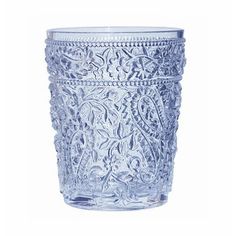 a clear glass with intricate designs on the rim and bottom, set against a white background