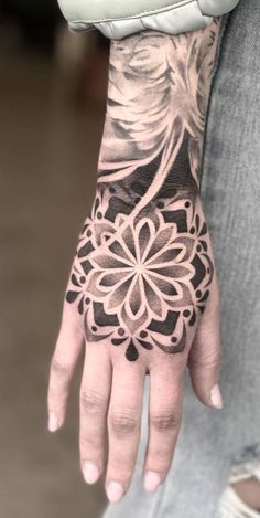 a person's hand with a tattoo on it, and a flower in the middle