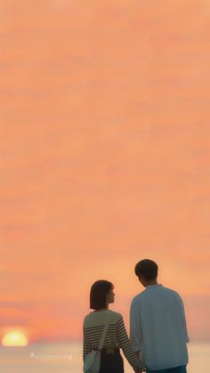 a man and woman are standing on the beach at sunset looking out to sea with an airplane in the sky