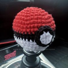 a crocheted hat is sitting on top of a car steering wheel knob cover