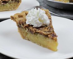 there is a piece of pie on the plate with whipped cream on top and another slice in the background