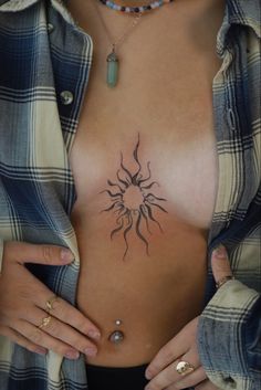 a woman's chest with a sun tattoo on it