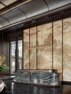 an elegant lobby with black marble counter tops and gold foil covering the wall behind it