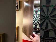 someone is holding their phone up to take a picture of the darts on the wall