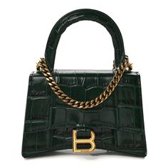 This is an authentic BALENCIAGA Shiny Calfskin Crocodile Embossed Hourglass Top Handle Bag Mini in Forest Green. This stylish and structured handbag is crafted of crocodile embossed green calfskin leather. The bag features a sturdy leather top handle, a prominent B logo on the front flap, and an optional, adjustable shoulder strap. The front flap opens with a magnetic snap closure to a smooth matching leather compact interior. Leather Laptop Sleeve, B Logo, Leather Laptop, Handle Bag, Green Leather, Leather Top, Emboss, Laptop Sleeves, Forest Green