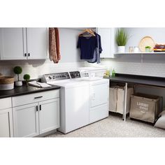 a washer and dryer sitting in a kitchen next to each other on top of cabinets