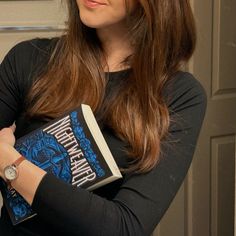 a woman is holding a book in her hands