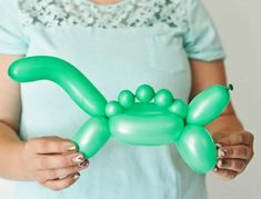 a woman is holding an inflatable balloon shaped like a dog's paw