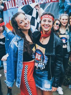 two women standing next to each other in front of a crowd