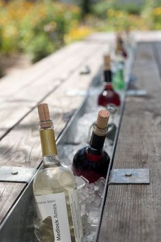 two bottles of wine sitting on top of a wooden table