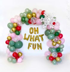 an arch made out of balloons with the words oh what fun on it