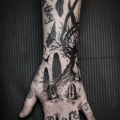 a person's hand with some tattoos on it