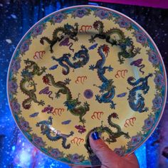 a person holding a plate with dragon designs on it