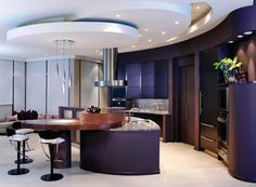 a modern kitchen with an island and bar stools in the center, surrounded by dark wood cabinetry