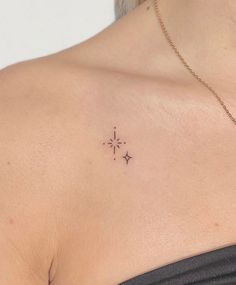 the back of a woman's shoulder with small stars on her left side and an arrow in the middle