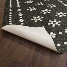 a black and white area rug with hexagon tiles on the floor next to it