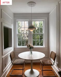 a dining room table with two chairs and a vase on the table next to it