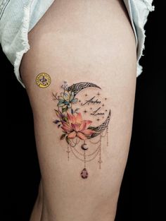 a woman's thigh with a clock and flowers on it