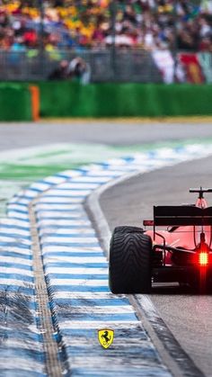 a red race car driving down the track