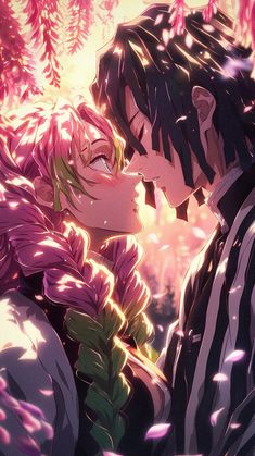 two people kissing each other in front of some pink flowers and leaves on the ground