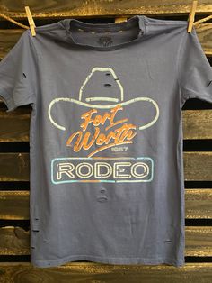 Country Deep Fort Worth 80's Rodeo vintage unisex distressed T shirt in vintage wash black and faded Navy Throw back vintage tee from 1980's 40 Singles Jersey 100% Cotton Premium quality ringspun and compacted cotton Fine Cotton Jersey that is pigment dyed for a more vintage look Features tears and destroyed features at neck and on body Each piece is unique as this process is done by hand! 3.8 oz Made In USA Every garment dye item can be a slightly different shade in color since this is a laundr Retro Faded T-shirt With Letter Print, Faded Distressed Crew Neck T-shirt, Vintage Faded T-shirt With Screen Print, Distressed Tri-blend Graphic Tee, Retro Distressed Faded T-shirt, Vintage Acid Wash Distressed T-shirt, Vintage Faded Short Sleeve T-shirt, Faded Vintage Crew Neck T-shirt, Faded Vintage Short Sleeve T-shirt