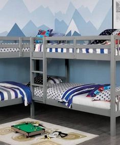 two bunk beds in a room with mountains painted on the wall and a pool table