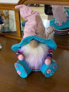 a small stuffed animal sitting on top of a wooden table next to a large mirror