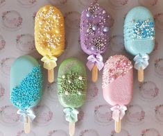 five different colored lollipops with bows on them