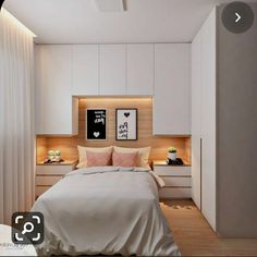 a bedroom with white walls and wooden flooring is pictured in this image, there are two framed pictures on the wall above the bed