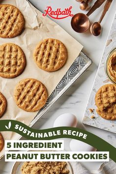 peanut butter cookies on parchment paper with spoons and utensils in the background