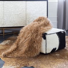 a cow hide rug on the floor in front of a mirror