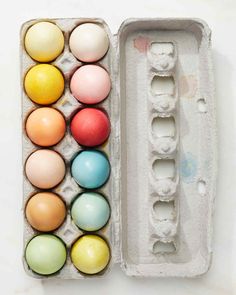 an egg carton filled with different colored eggs on top of a white countertop