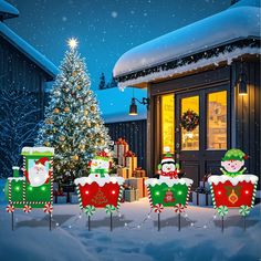 christmas decorations in front of a house with snow on the ground and a lit up christmas tree