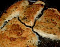 four pieces of chicken cooking in a frying pan