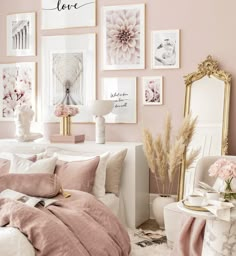 a bedroom with pink walls and pictures on the wall above it, along with white furniture