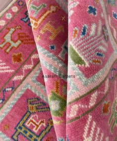 close up view of pink carpet with multicolored design on the back and sides