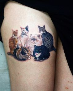 a woman's thigh with cats on it and one cat sitting in the middle