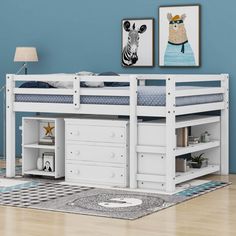 a white bunk bed sitting on top of a wooden floor next to a blue wall