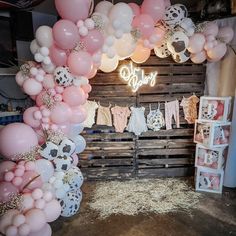 a bunch of balloons that are hanging on a wall in front of a baby's room