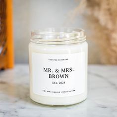 a white candle sitting on top of a marble counter next to a bottle of wine