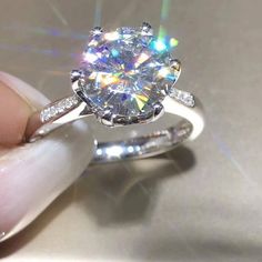 a person holding a diamond ring in their hand