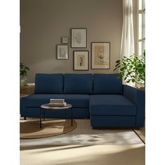 a living room with a blue sectional couch and coffee table in front of a window