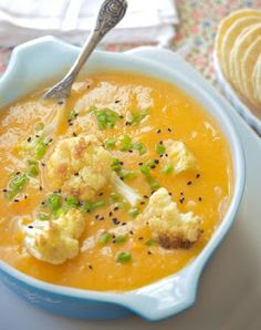 a bowl of soup with cauliflower and green onions