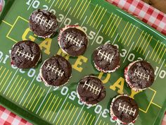 chocolate football cupcakes on a green tray with a red and white checkered tablecloth