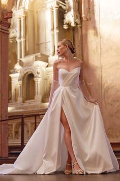 a woman in a white wedding dress standing on the floor